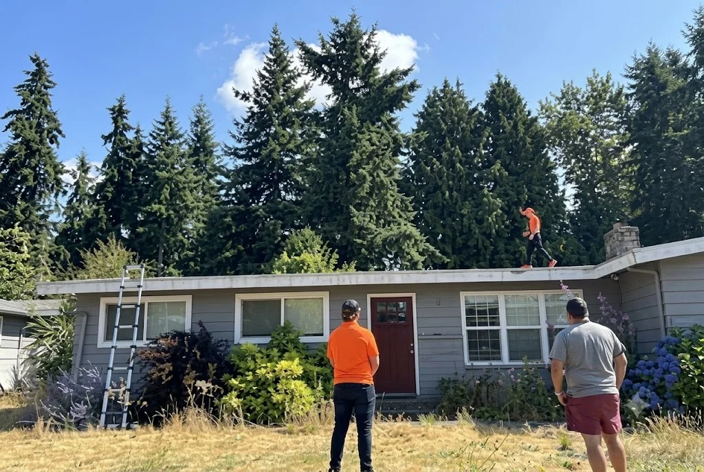 Professional roofer inspecting residential roof in Seattle area